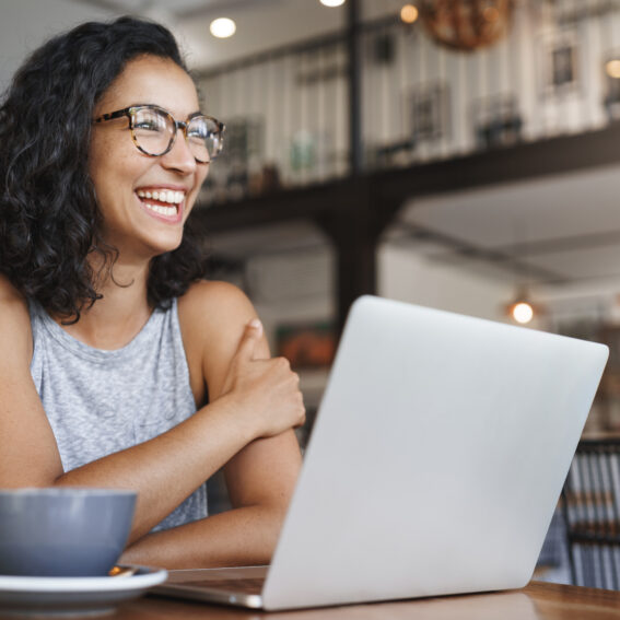 Female smiling in front of computer.