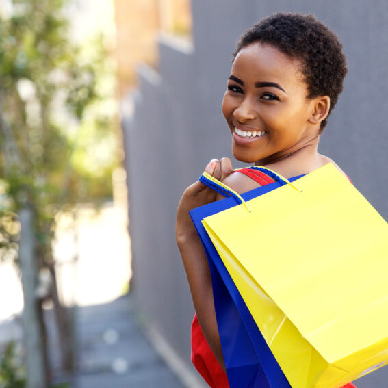 African-American female holding shopping bags.