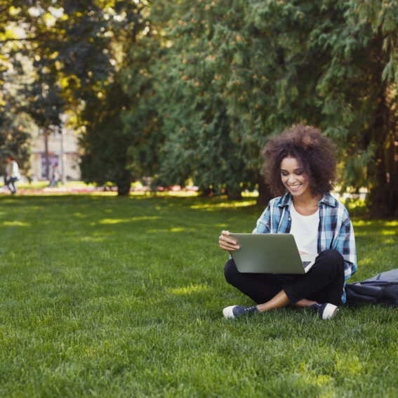 Student studying in the grass.